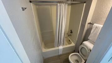 A bathroom with a bathtub, shower, and toilet.