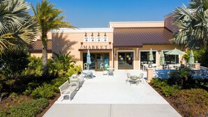 A building with a 'MARKET' sign, outdoor seating, and palm trees. - 1798 TP - 4BR Luxury Solara Retreat Pool Disney (Kissimmee)