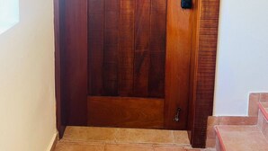 Una puerta de madera con un ojo de cerradura y un timbre.