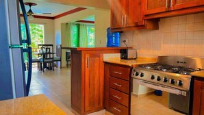 Una cocina con armarios de madera, una estufa a gas y un dispensador de agua azul.