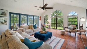 A spacious living room with a high ceiling, large windows, and a ceiling fan. - ‘Our Encanto’ -quiet golf course view-Tampa suburb (Valrico)
