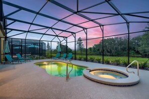 A pool area with a glass enclosure, lounge chairs, and a hot tub. - Near Disney. w/ private POOL/SPA/GAME ROOM (Davenport)
