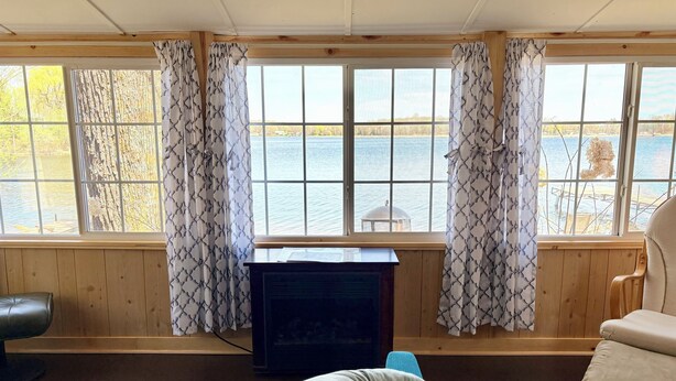 A room with a wooden interior, a television, a sofa, and a chair. - Lakefront Cabin w/ Dock & Kayaks, Perfect Summer Stay
Rustic Nautic - Cabin 9 (South Haven)