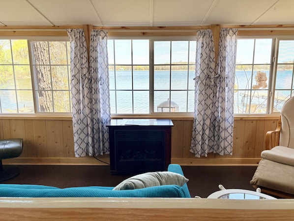 Una habitación con paredes de madera, un televisor, un sofá y una silla.