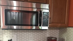 Eine Küche mit Edelstahl-Mikrowelle, Kaffeemaschine und Toaster auf der Arbeitsfläche.