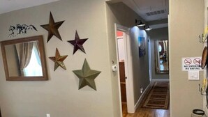 Ein Korridor mit Holzboden, einem Spiegel und Sternen an der Wand.