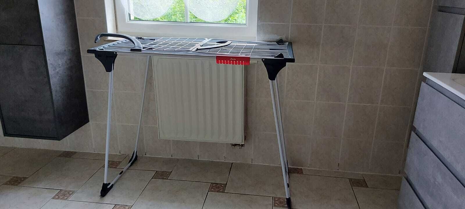 Een kamer met een radiator, een raam en een betegelde vloer.