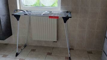Een kamer met een radiator, een raam en een betegelde vloer.