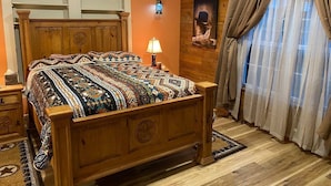 Un dormitorio con cama de madera, mesita de noche, lámpara y ventana con cortinas.