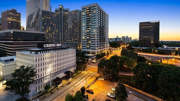Un paisaje urbano moderno con edificios altos, incluyendo un edificio destacado que dice "CRISTO REY".