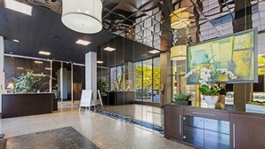 Un vestíbulo moderno con mostrador de recepción, ventanas amplias y plantas de interior.