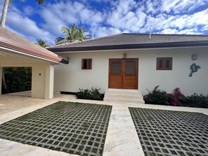 A two-story house with a wooden front door, a small window, and a covered porch area. - Casa Ola, Lux 5 Bedrm, 5 Bath Villa, w' Private Pool, 2 min walk to Playa Coson (Las Terrenas)