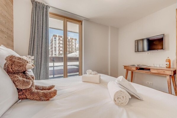 Relax in a spacious room with a large bed, desk, and flat-screen TV, offering a city view.