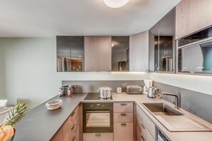 Enjoy cooking in this kitchen with a stainless steel sink, oven, and microwave.