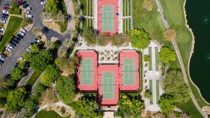 An aerial view of a sports complex with multiple tennis courts, parking areas, and surrounding greenery. - Tranquility in Trilogy (Peoria)