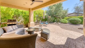 An outdoor patio with wicker furniture, a ceiling fan, and a grill. - Tranquility in Trilogy (Peoria)