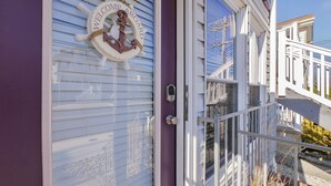 A house with a purple exterior, a white door with a 'Welcome Aboard' sign, and a metal gate leading to a porch. - BeachBlockParadise=ParkSpot~Also See BeachBlockSeaEscape.          VRBO#3830716  (Ocean City)