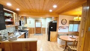 Una cocina amplia con armarios de madera, una isla central y un comedor con mesa y sillas.