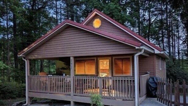 Une cabane dotée d’un porche, d’une petite terrasse et d’un espace extérieur couvert.