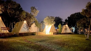 A row of tents in a campsite at night with artificial lighting. - Natura Fun House & Camping (Sintra)