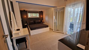Ein modernes Schlafzimmer mit Bett, Nachttischen und einer Glastür zum Balkon.