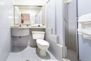 Un baño pequeño y moderno con inodoro, lavamanos y ducha.