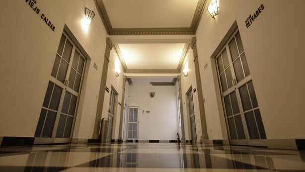 A hallway with a polished floor, double doors, and wall-mounted lights. - Hotel Escorial (Manizales)