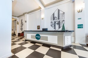 Una recepción con piso a cuadros, un reloj en la pared y una decoración navideña.