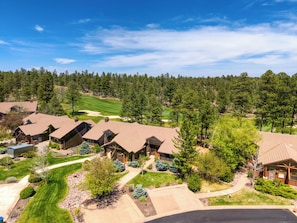 A residential area with multiple houses, a golf course, and a forested backdrop. - Torreon Dream Cabin (Show Low)