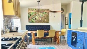 Una cocina moderna con estufa a gas, armarios de madera y un comedor con alfombra azul.