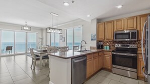 A modern kitchen with a central island, stainless steel appliances, and wooden cabinets.