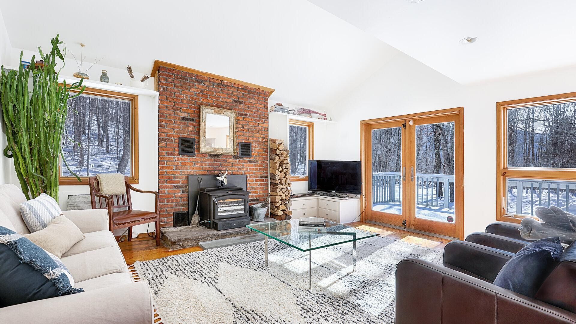 Nhà, nhiều giường (Valley Stream Charm) | Khu phòng khách | TV, lò sưởi, sách 