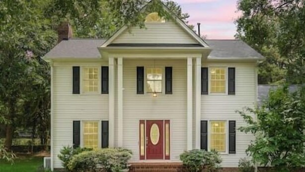 A two-story house with a front entrance, a red door, and a small front yard. - Beautiful Home Walking Distance to Elon University (Elon)