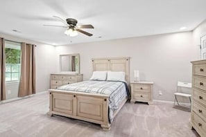 A bedroom with a bed, nightstands, a dresser, a ceiling fan, and a window. - Beautiful Home Walking Distance to Elon University (Elon)