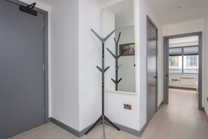 A hallway with a coat rack, a door, and a window. - Centrally Located 1BD Flat in the Heart of London (London)