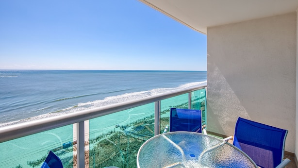 Ein Balkon mit freiem Blick auf das Meer und eine entfernte Küste.