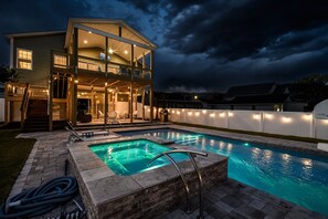 A two-story house with a swimming pool, a covered deck, and a well-lit interior. - 4BD Pet Friendly-Private Pool and Hot Tub-Walk 2 Beach (North Myrtle Beach)