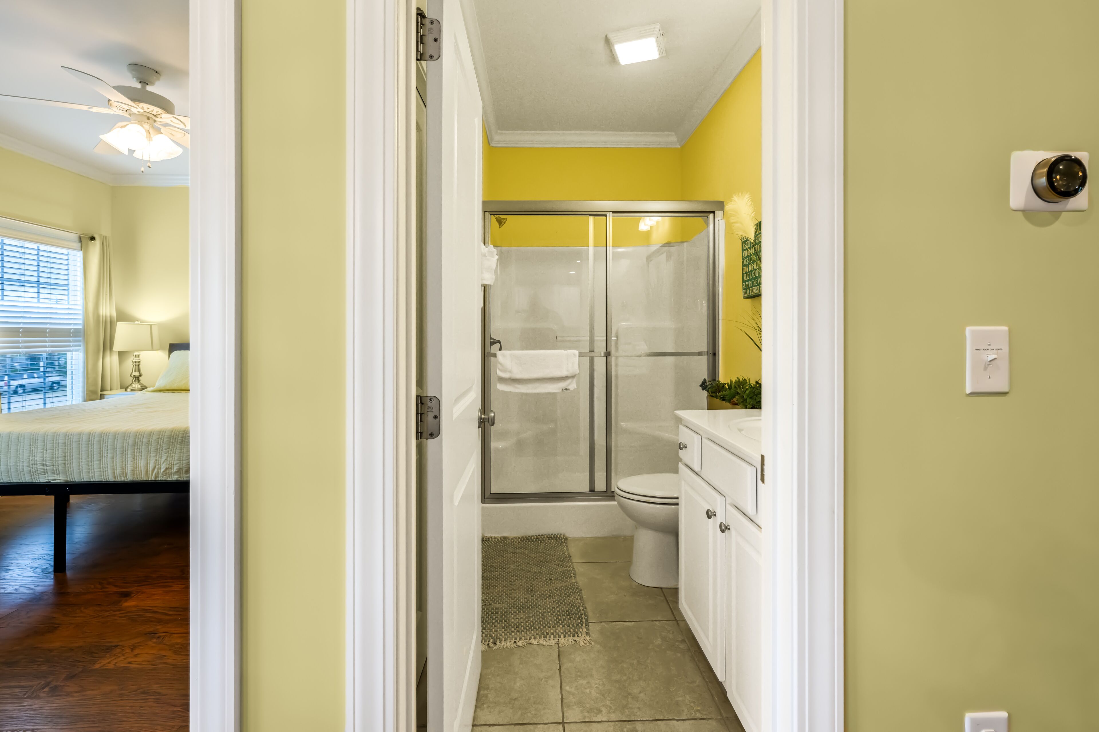A bathroom with a glass shower enclosure, a toilet, and a sink.