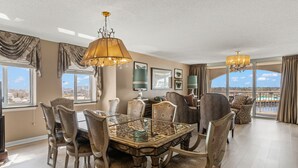 A dining area with a glass-top table, ornate chairs, and chandeliers. - Spectacular 3BD Corner Unit - Waterway Views - Large Square Footage (North Myrtle Beach)