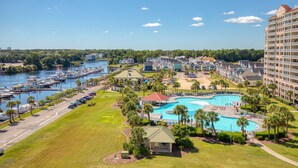 A resort with a large swimming pool, marina with boats, and a hotel with multiple floors. - Spectacular 3BD Corner Unit - Waterway Views - Large Square Footage (North Myrtle Beach)