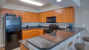 A modern kitchen with wooden cabinets, a black refrigerator, a microwave, and a stove. - Beautiful Oceanfront-3BD-Pool/Hot Tub/Lazy River-Bahama Sands (North Myrtle Beach)