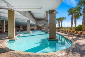 An indoor swimming pool with clear water, surrounded by lounge chairs and palm trees. - Beautiful Oceanfront-3BD-Pool/Hot Tub/Lazy River-Bahama Sands (North Myrtle Beach)