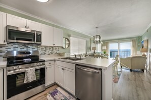 Enjoy a serene ocean view from the dining area, adjacent to a spacious kitchen with appliances and a large island.