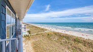 A beach view from a building with a covered patio, sandy beach, and ocean. - Sea Oats D-3, 3BD 2BA Oceanfront Paradise (North Myrtle Beach)