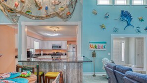 A spacious kitchen with white cabinets, a central island, and a dining area with a wooden table and chairs. - 4BD Beach House-Private Pool-3 Min Walk 2Beach (North Myrtle Beach)