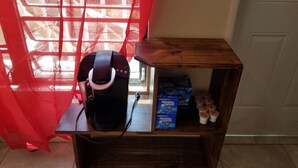 A Keurig coffee maker on a wooden shelf with a window in the background. - Apartment with bath, tv, ac and a view to die for (Estate Bovoni)