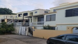 A residential building with multiple floors, balconies, and a staircase leading to the upper levels. - Apartment with bath, tv, ac and a view to die for (Estate Bovoni)