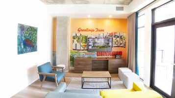 A modern living room with a television, seating area, and a wall mural.