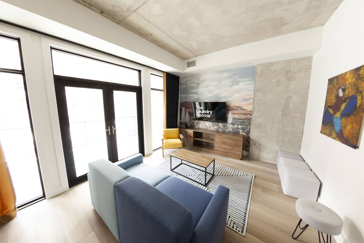 Una sala de estar moderna con un sofá, una mesa de centro, un televisor y una chimenea.