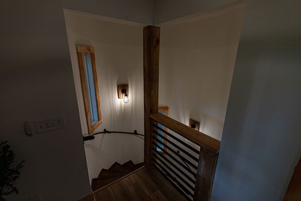 A staircase with wooden railings and a small window at the top.